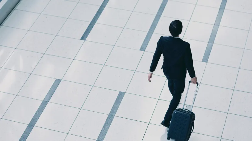 Corporate traveler walking into hotel during travel disruption
